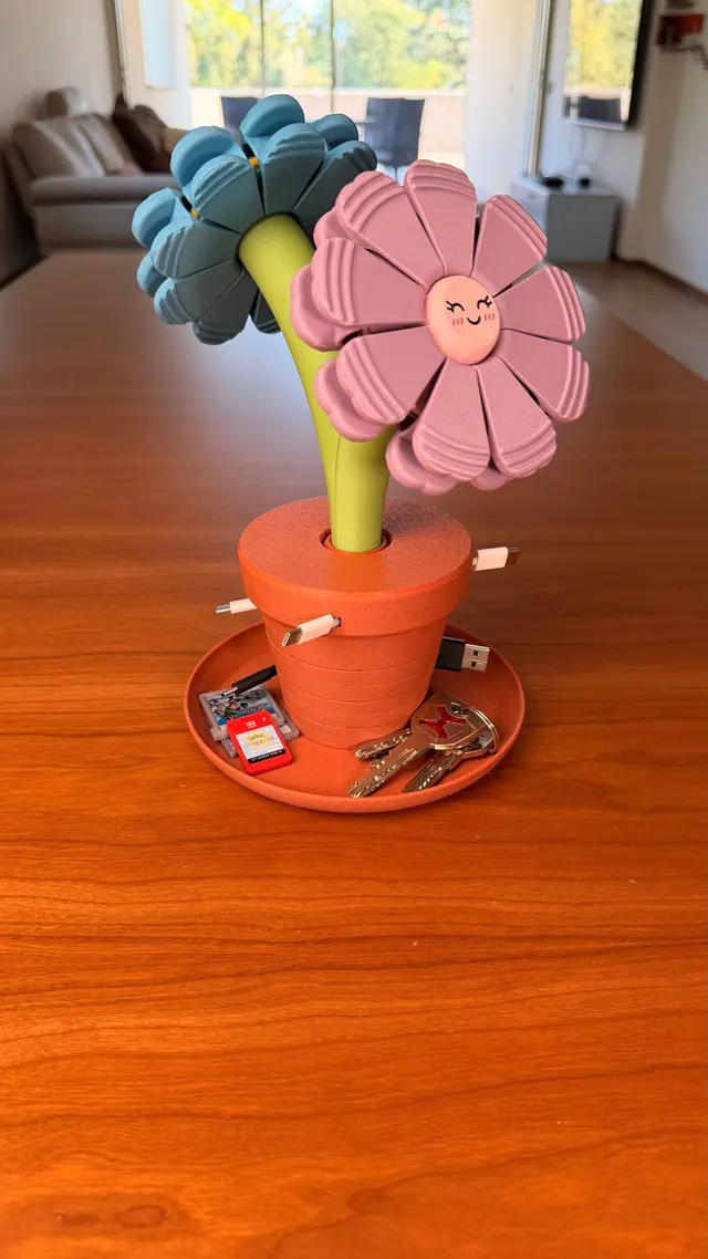 Vaso Bloom Stack con due fiori magnetici, uno azzurro e uno rosa, su un sottovaso arancione